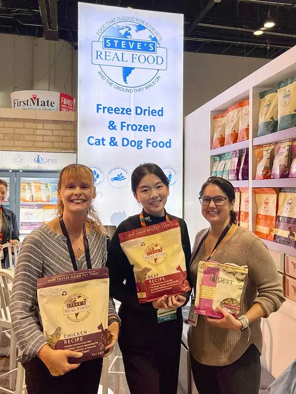 Three women working in convention booth